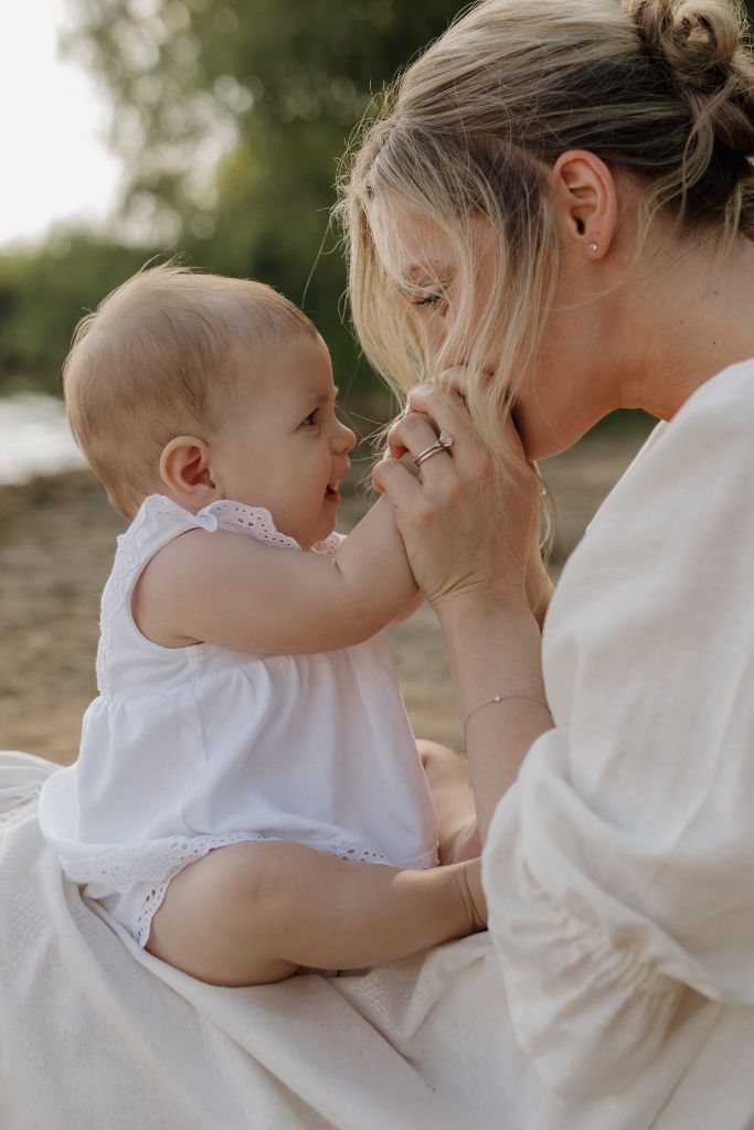 Hadley gently kissing baby Freya's hands